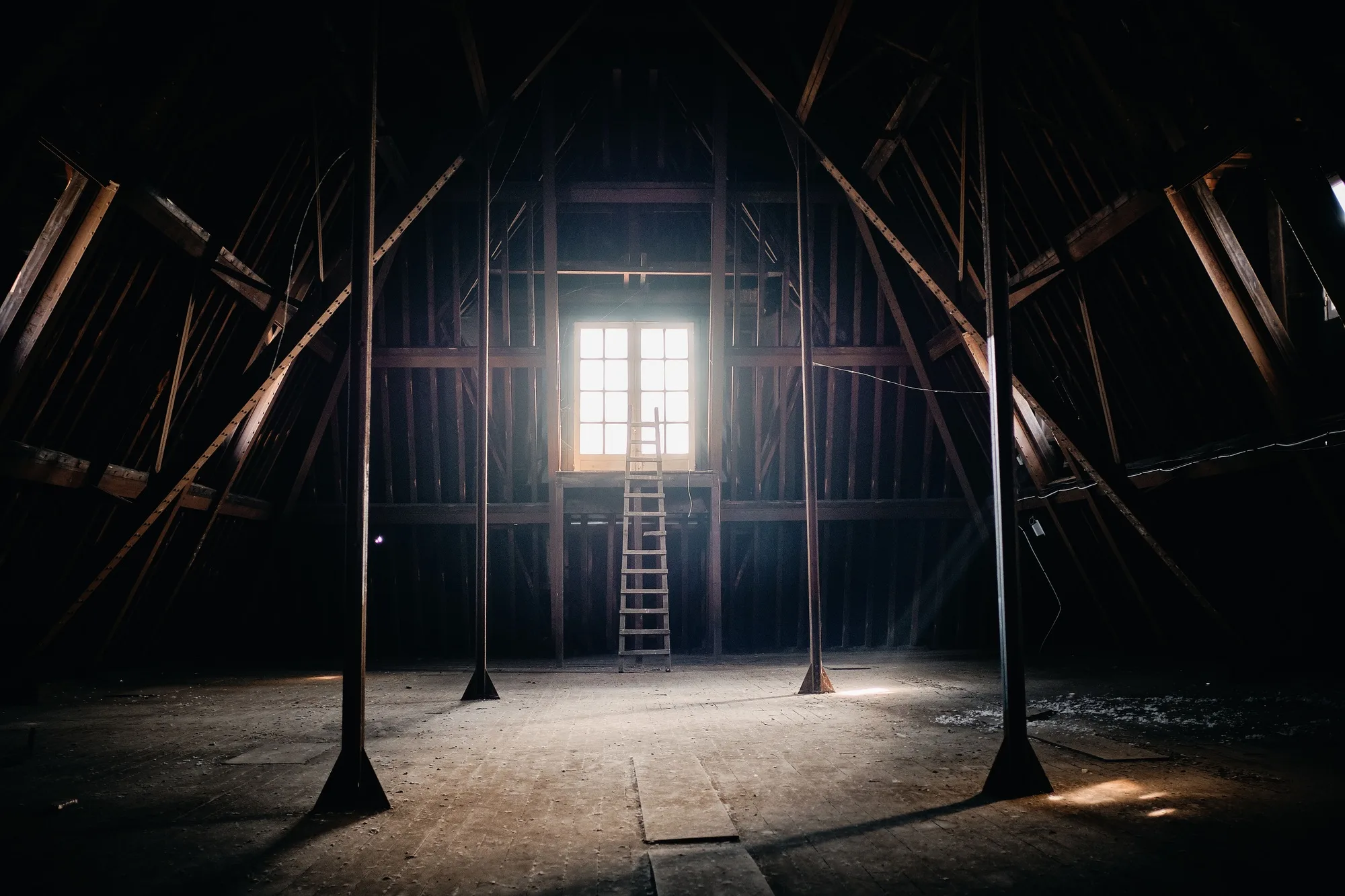 Ancient building attic with wooden columns and a small window in Roubaix, France